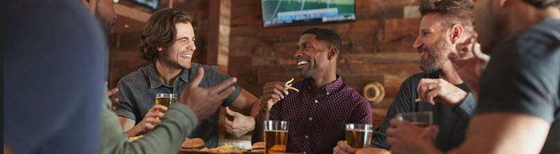 Male Friends Drinking Beer In Sports Bar